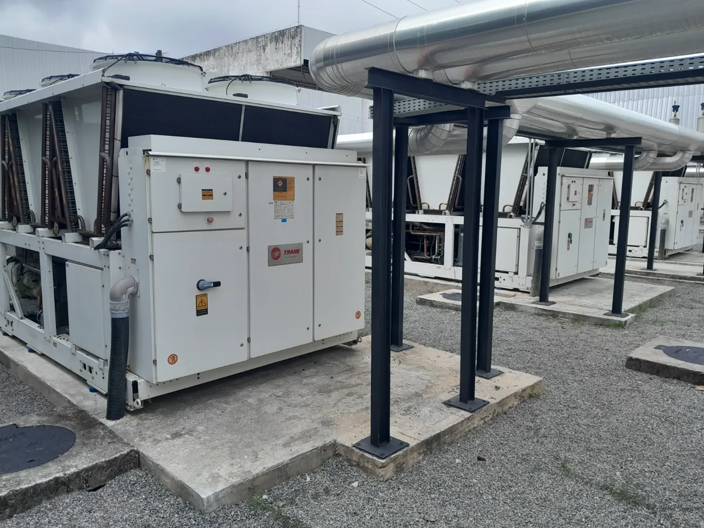 Pátio de chillers Trane resfriados a ar interligados por tubulação isolada